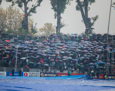 Under the Umbrella: Spectators wait for Nepal-UAE cricket match to resume