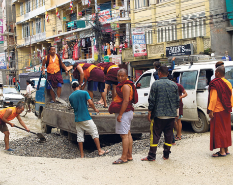 Monks take initiative to fill the potholes of Bauddha-Jorpati road