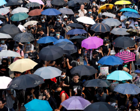 Thousands march in Hong Kong as police in black masks look on