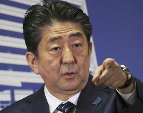 The Latest: Exit polls show Abe’s ruling bloc wins elections
