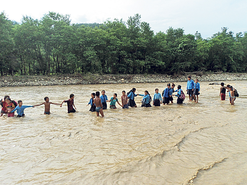 Children brave flooded river to reach school