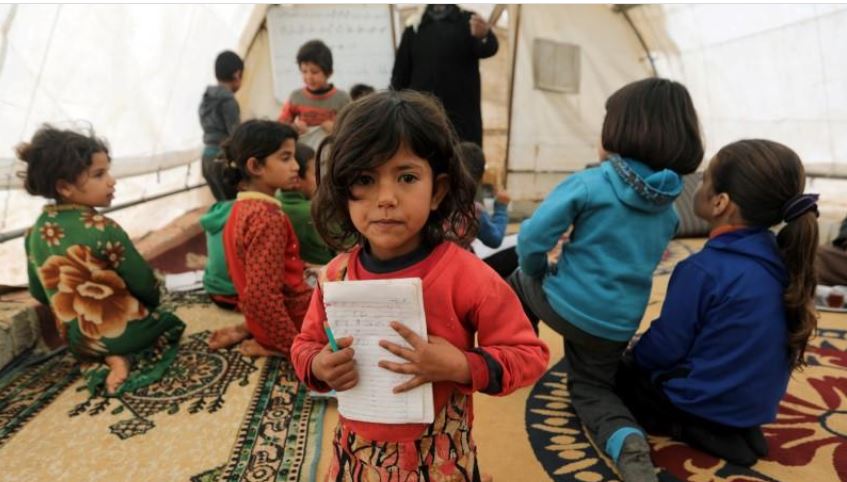 Having fled bombing, Syrian children learn to read in borderland tent schools
